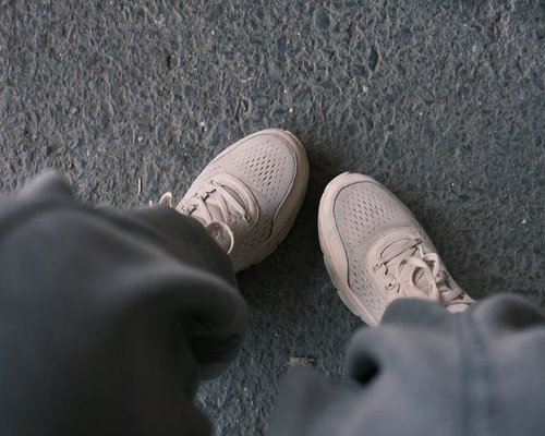 A flat-lay view of comfortable walking shoes on a city sidewalk representing short urban walks
